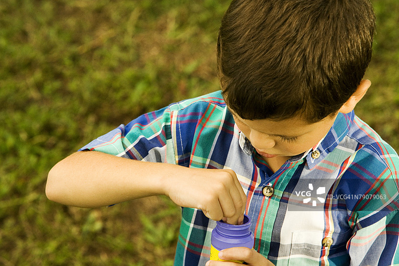 高角度视图的男孩手持塑料瓶图片素材