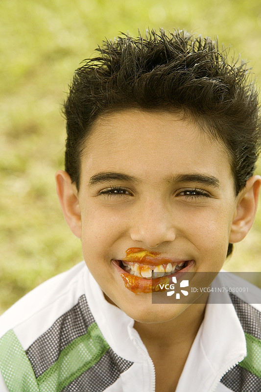 一个面部脏乱但微笑的男孩肖像图片素材