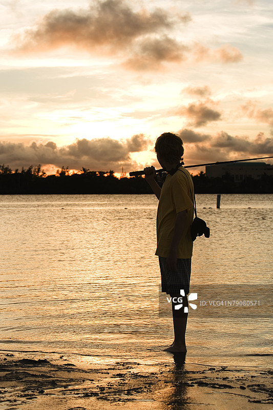 一个男孩提着钓鱼竿的剪影图片素材