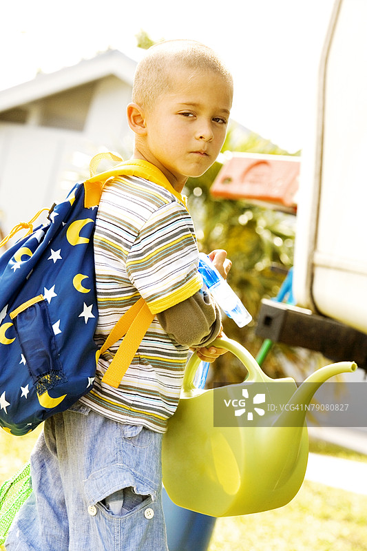 一个男孩手持浇水壶的肖像图片素材