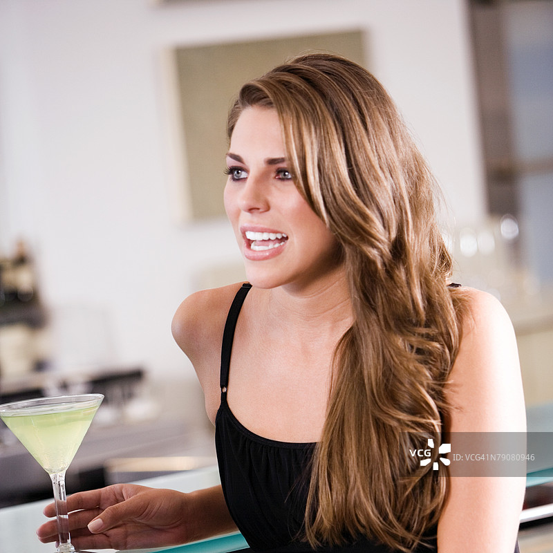 年轻女性手持鸡尾酒的特写镜头图片素材