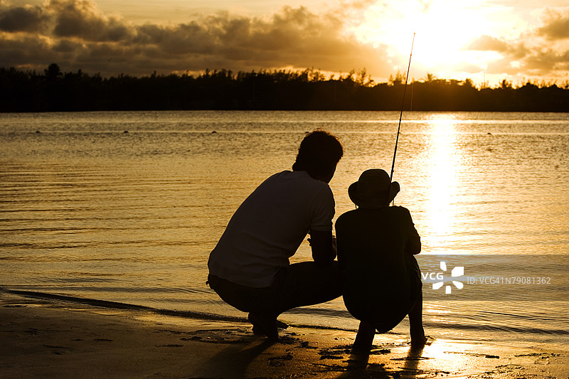 父亲和儿子钓鱼的剪影图片素材