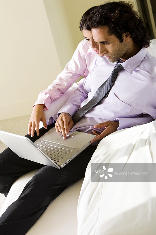 高角度视图的男商人和女商人在使用笔记本电脑图片素材