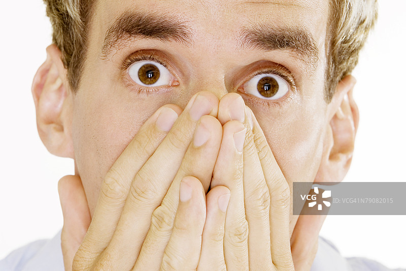 年轻男子用手捂住嘴巴的肖像图片素材