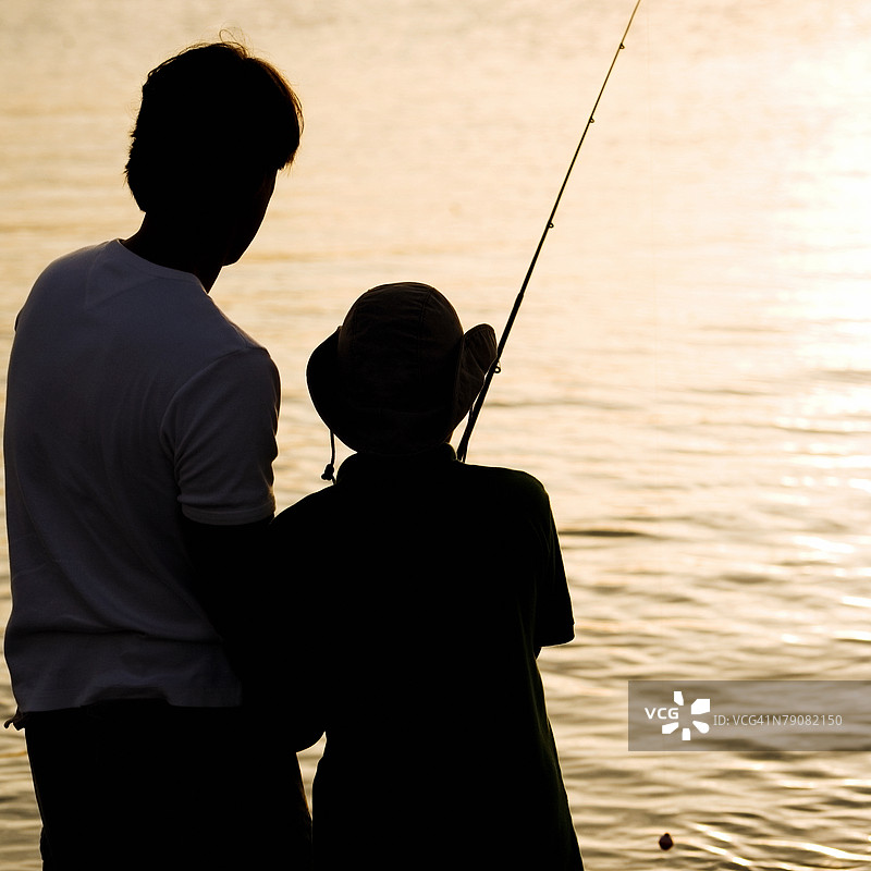 父亲和儿子钓鱼的剪影图片素材