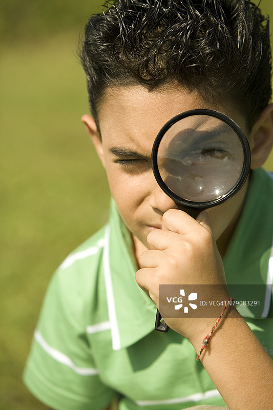 用放大镜观察的男孩特写图片素材
