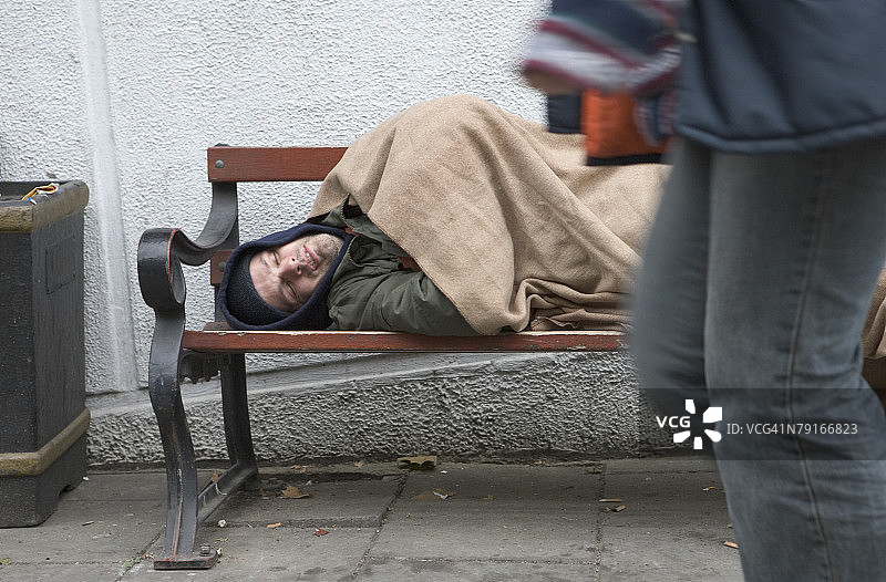 男子在户外长椅上睡觉图片素材
