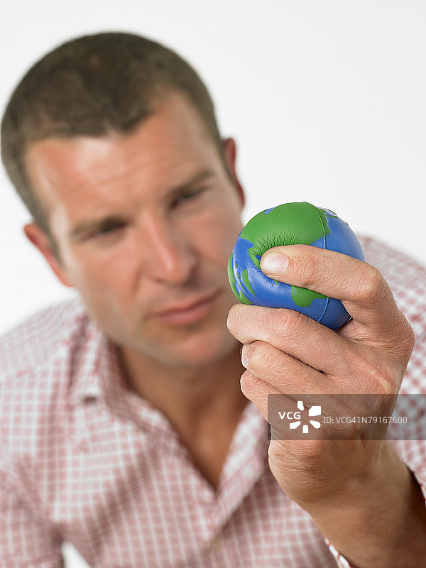 手持迷你地球仪的男人图片素材