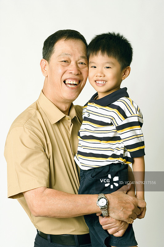 一位老年男子抱着他的孙子肖像图片素材