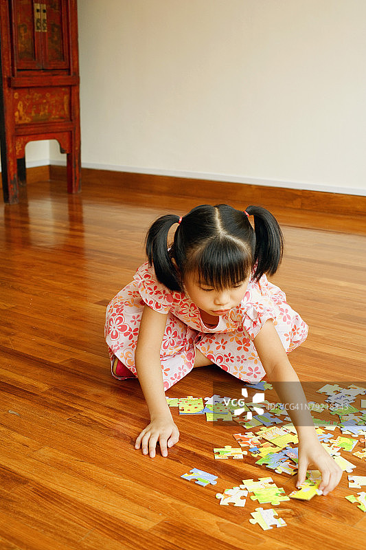 女孩坐在地上玩拼图特写图片素材