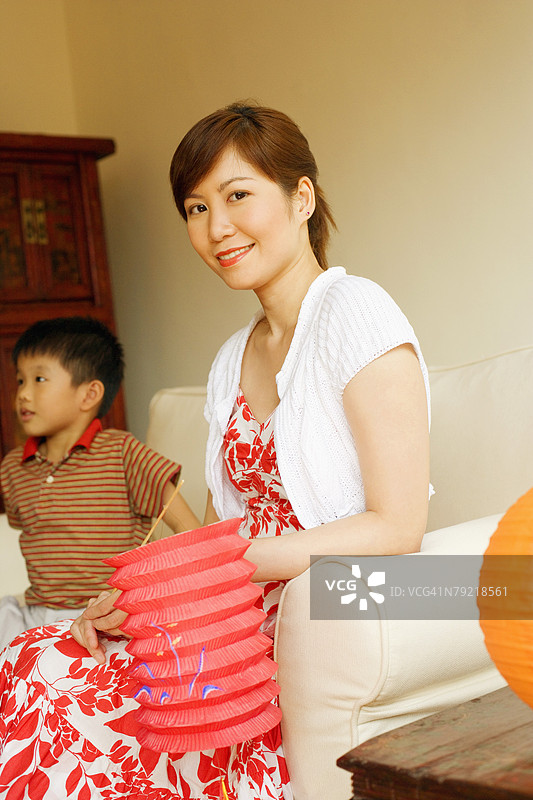 年轻女性手持中国灯笼，身旁是她的儿子图片素材