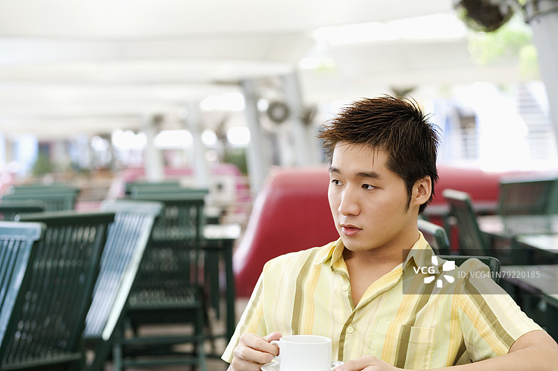 年轻男子手持咖啡杯图片素材