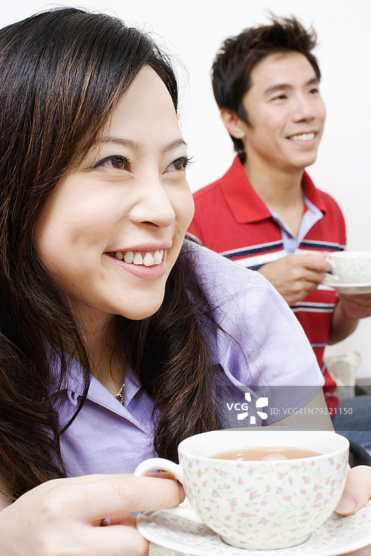 年轻女性和中年男性喝茶的特写镜头图片素材
