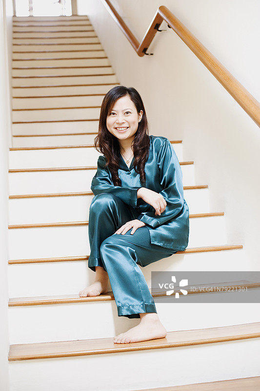 年轻女性坐在楼梯上的肖像图片素材