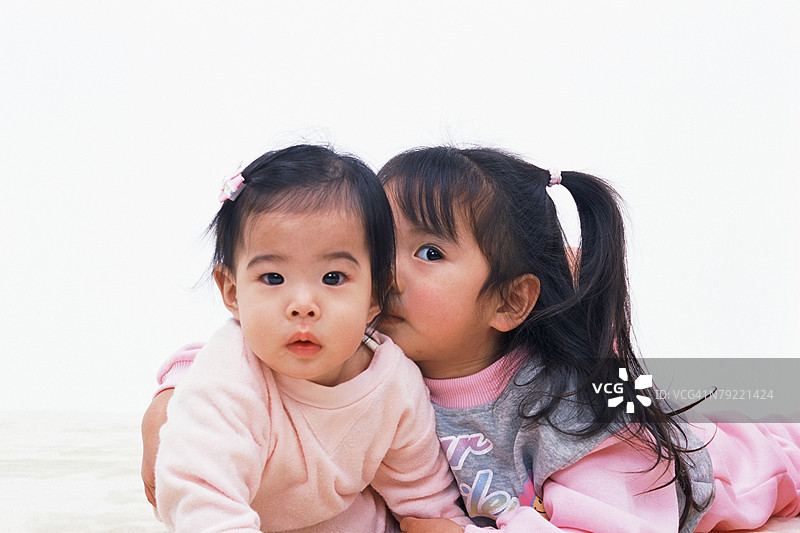 一个女孩抱着一个婴儿图片素材