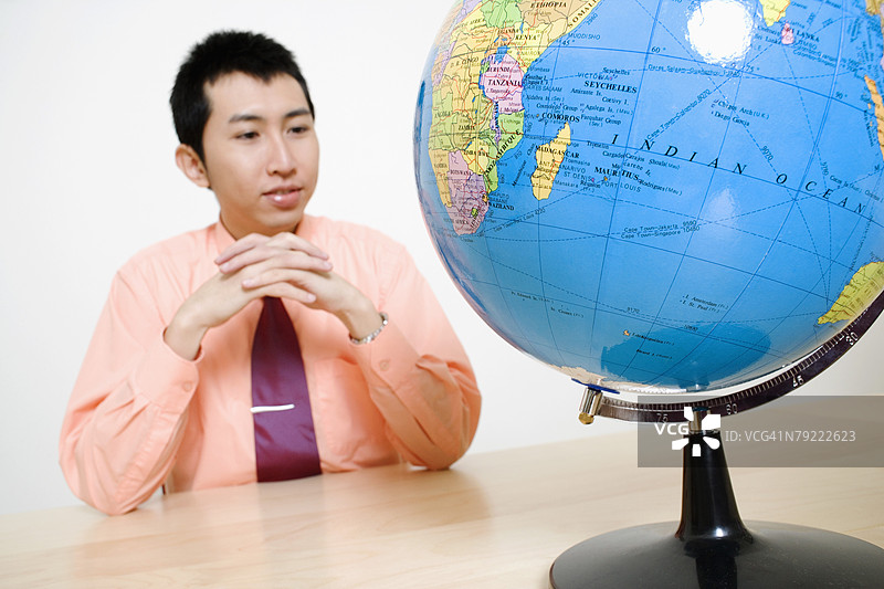 商人正在看着地球仪图片素材