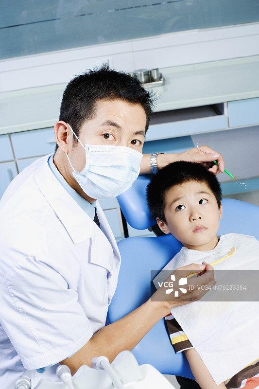 男牙医给男孩检查肖像图片素材