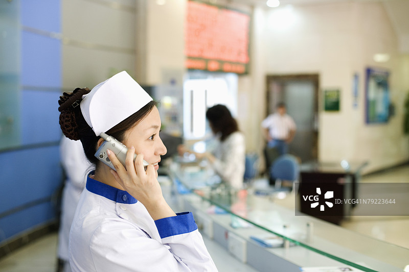 用电话交谈的女护士侧面照图片素材
