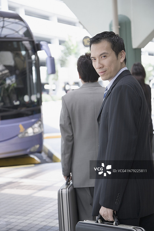 一位商人手持公文包走路的肖像图片素材