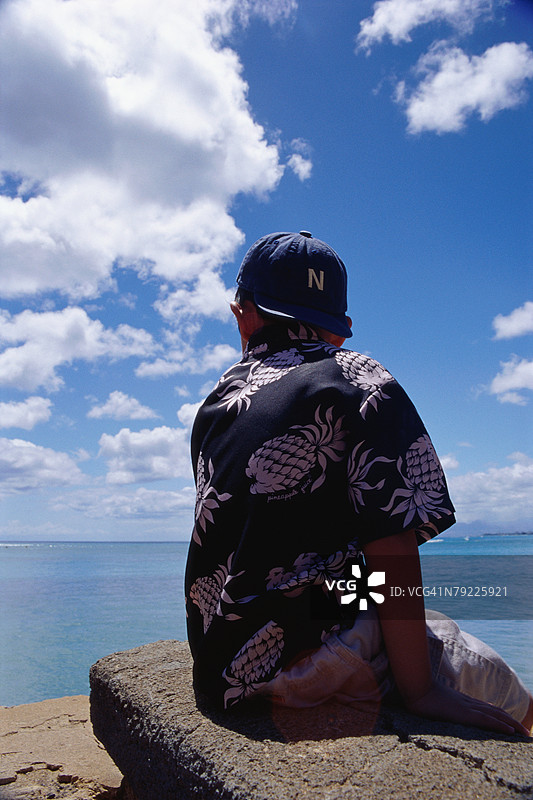 男孩坐在岩石上图片素材