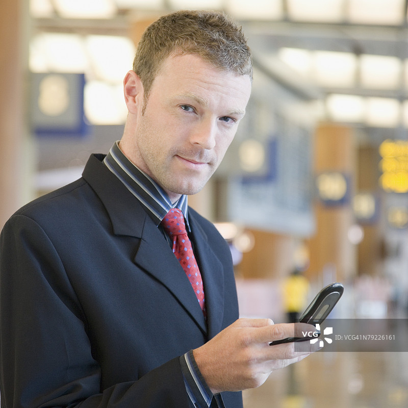 在机场贵宾室内使用手机的商人肖像图片素材