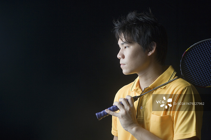 年轻男子手持羽毛球拍的特写镜头图片素材