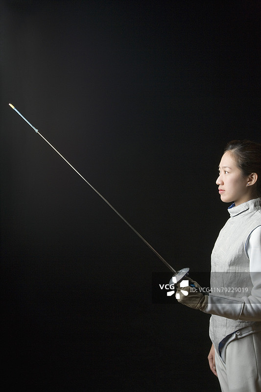 侧面轮廓：女击剑手拿着击剑花剑图片素材