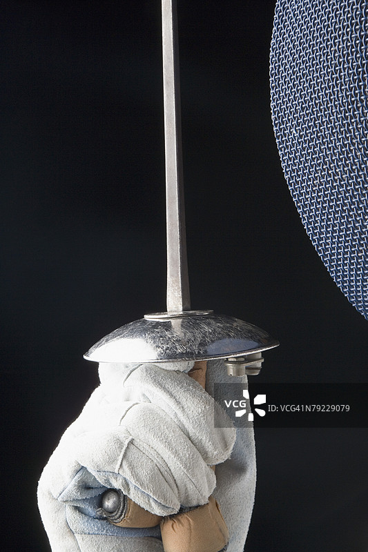 特写镜头展示一个人手握击剑剑。图片素材