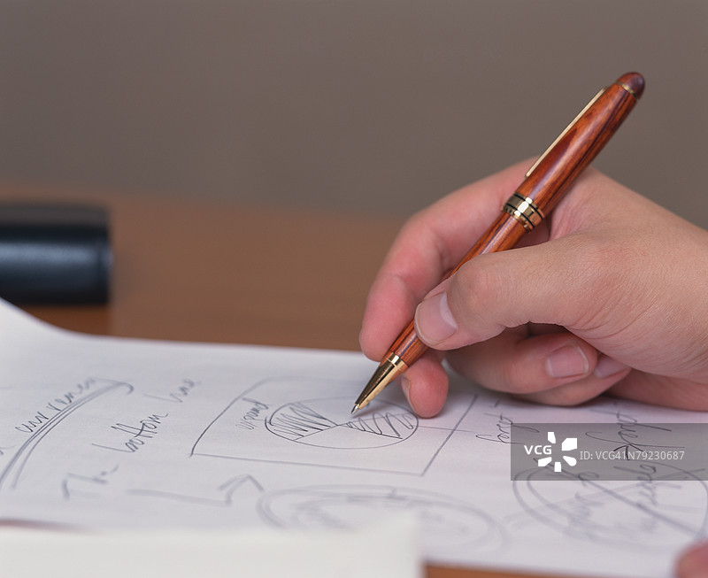 特写的人手握着一支钢笔图片素材