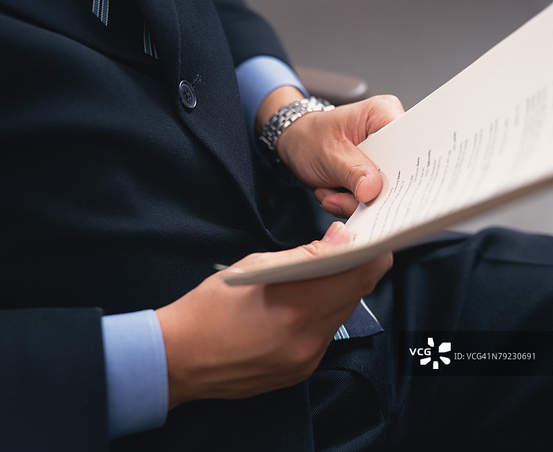 一个人手持某些办公文件的中部特写图片素材