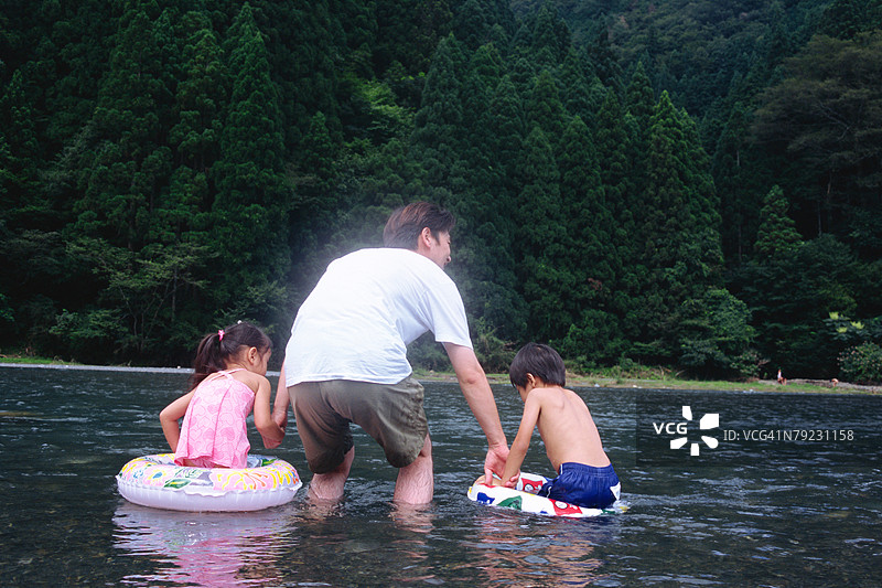 父亲和孩子们在河里图片素材