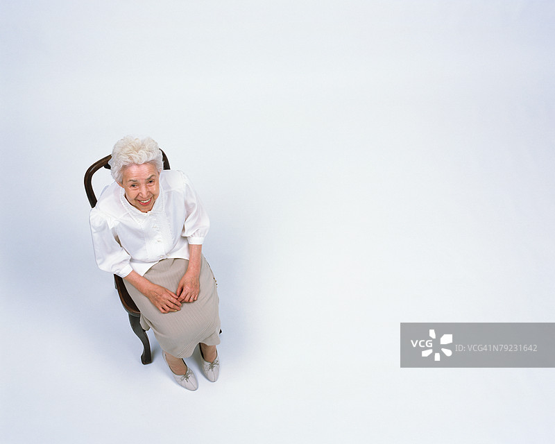 一位老年女性坐在椅子上图片素材