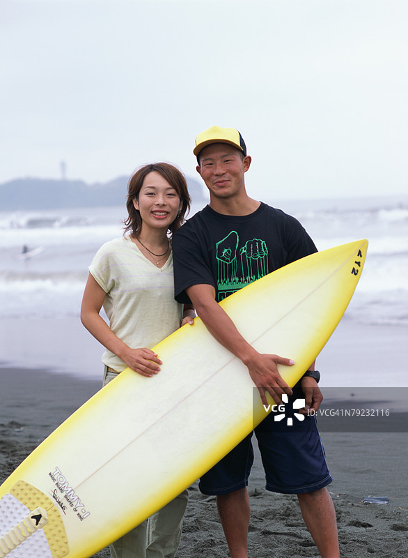 年轻情侣手持冲浪板图片素材