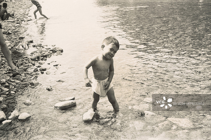 男孩在河岸边玩耍图片素材