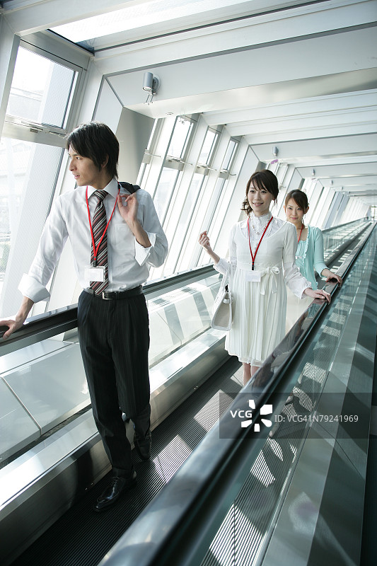 商人和两位女士乘坐自动扶梯图片素材