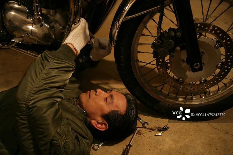 中年男人修理摩托车图片素材