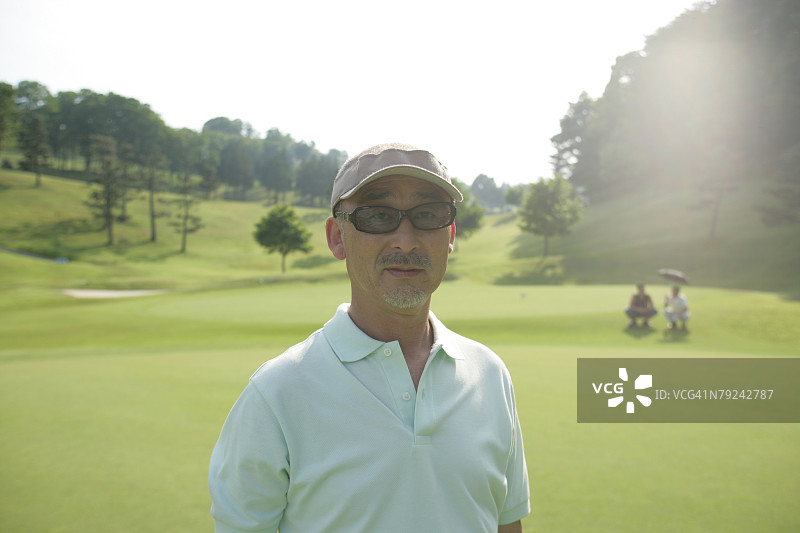 站在高尔夫球场上的男人图片素材
