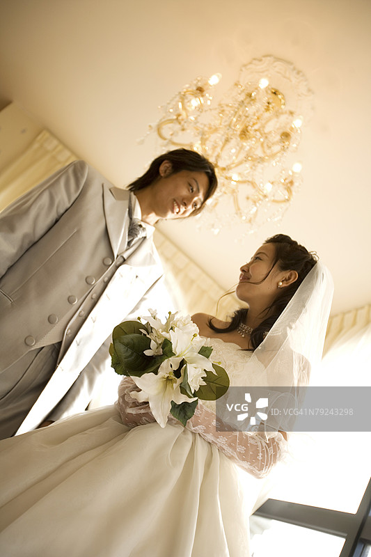 新娘和新郎站在一个房间里，低角度视图图片素材