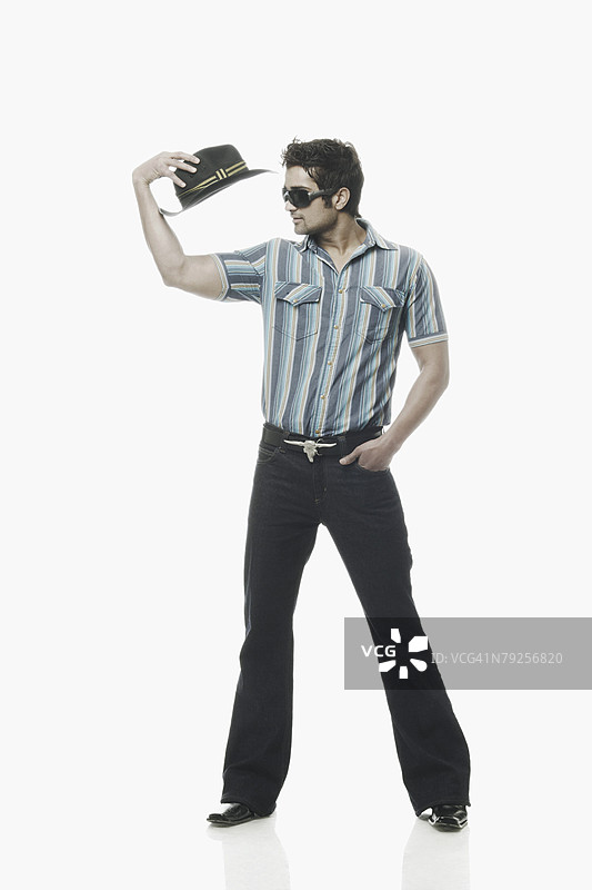 年轻男子手持一顶帽子图片素材