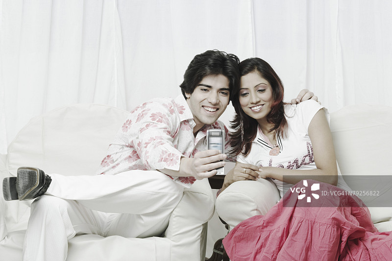 年轻情侣看着手机图片素材