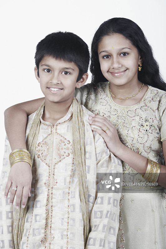 与哥哥/弟弟搂着手臂站在一起的女孩肖像图片素材