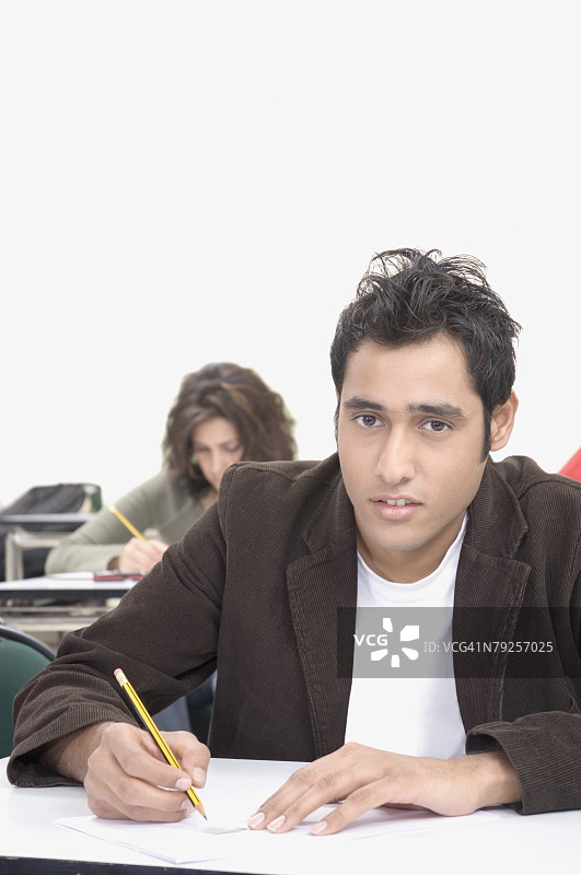 在教室里参加考试的男大学生肖像图片素材