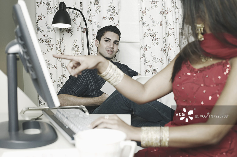 年轻女性特写，指向电脑显示器图片素材