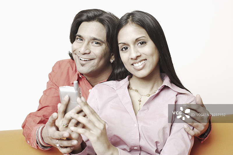 一对年轻情侣手持手机的肖像图片素材