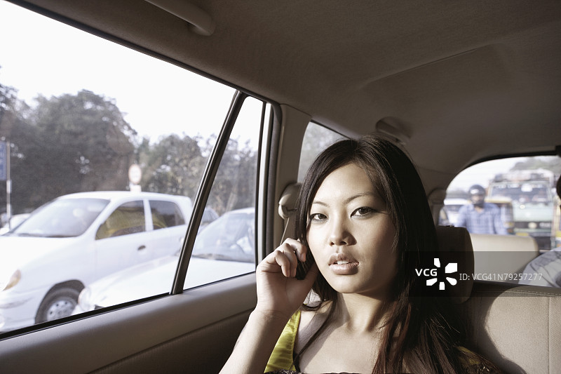 年轻女子在车里用手机交谈的人物肖像图片素材