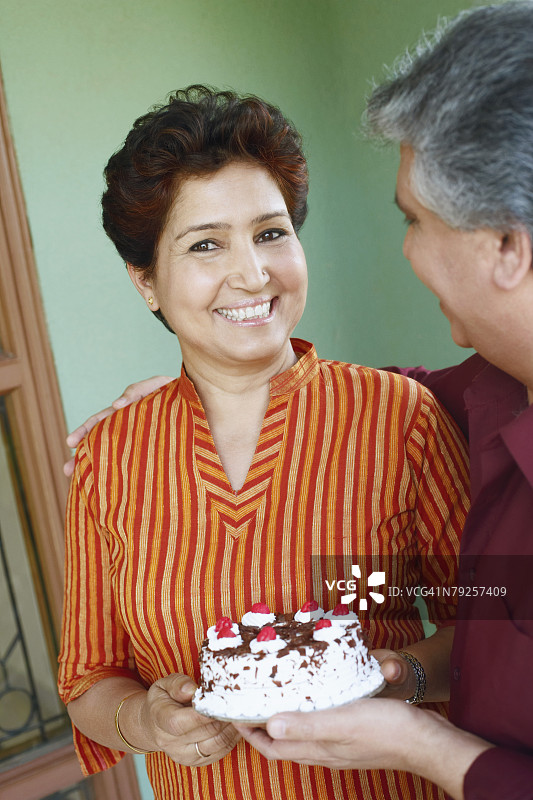 一对中年夫妇手捧生日蛋糕的特写图片素材