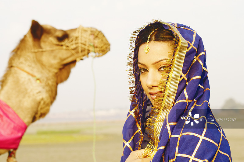 年轻女人与背景骆驼特写图片素材