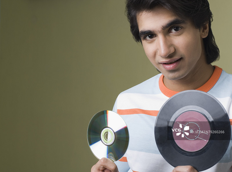 拿着唱片和CD的年轻男人肖像图片素材