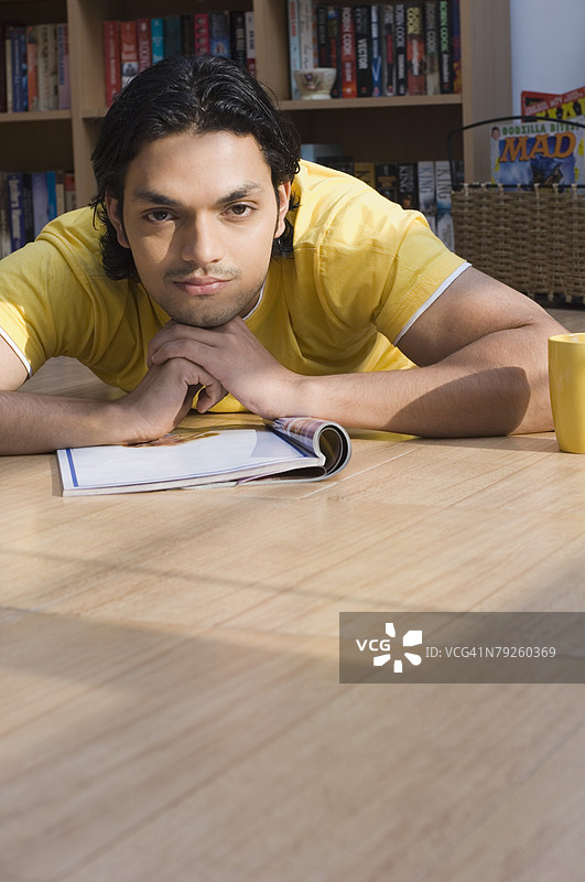 年轻男子躺在图书馆的地板上思考图片素材