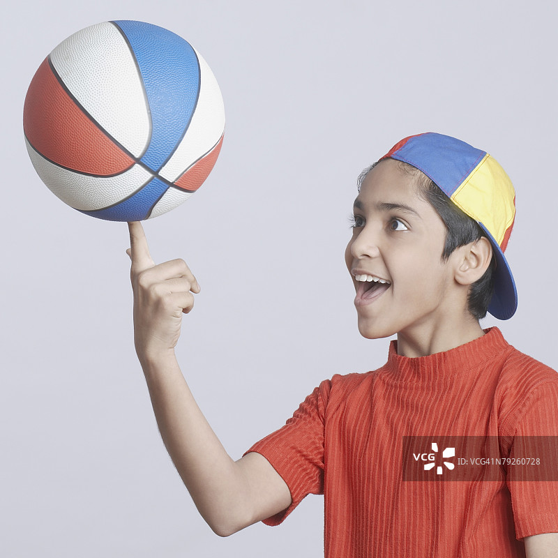 男孩用手指转篮球的特写图片素材